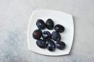 juicy ripe black and blue plums on a plate