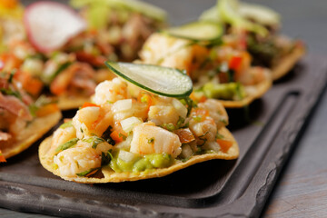 Tuna, shrimp and octopus toast snacks with radish, cucumber and avocado.
