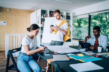 Obraz premium Young diverse colleagues working in creative workspace