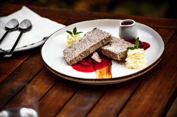 Frozen dessert (parfait) with poppy seeds, plum sauce, whipped cream and hot chocolate.