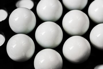 Group of shiny white spheres on black background.