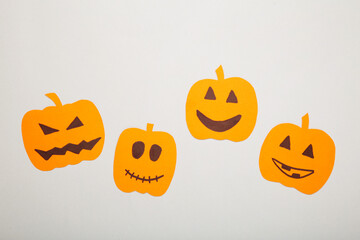 Halloween decorations with paper pumpkins on grey background.