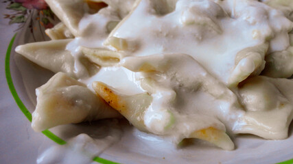 Traditional Turkish cuisine Ravioli, Manti Manlama serving with yogurt and fried butter sauce. 