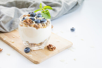 Healthy blueberry and walnut parfait in a glass on a white background