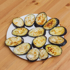 Plate with fried zucchini eggplant vegetables on table