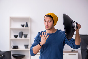 Young male photographer working in the studio