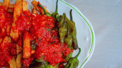 Fried green pepper covered with organic tomato sause in the white plate