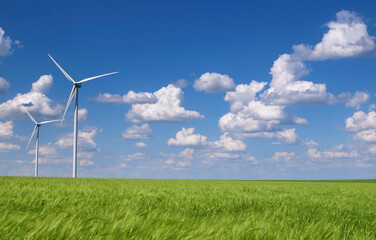 Beautiful landscape with wind turbine, green wheat crop and cloudy blue sky