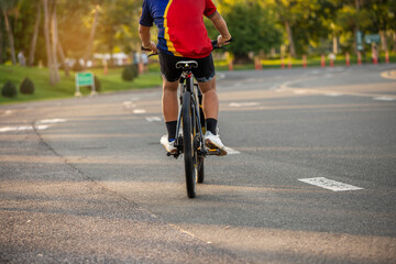 Naklejka na ściany i meble Healthy athlete man exercising cycling in the park.