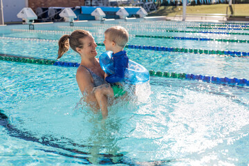 Naklejka premium Mother and little boy in swimming pool outside in sunny day, smiling face, enjoy in the water, close up portrait.