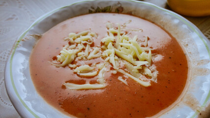 Fresh tomato soup with cheese in the white plate
