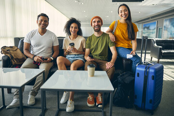 Happy cheerful friends staying in international terminal