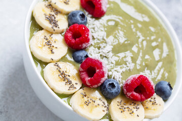 Healthy Breakfast smoothie in a bowl with hemp protein, kiwi, banana, coconut, raspberries, blueberries and Chia seeds.