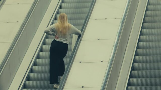 Back view of Swedish woman on Stockholm Metro escalator. Sweden