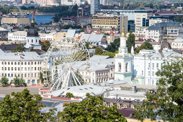 Kiev, Ukraine, panoramic view of the old city, ferris wheel, old historical buildings and church, tourism and sightseeing concept