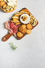 Fototapeta na wymiar Wooden board with cheese, ham, bread stick, nut cashew, walnut and honey on camembert on white background