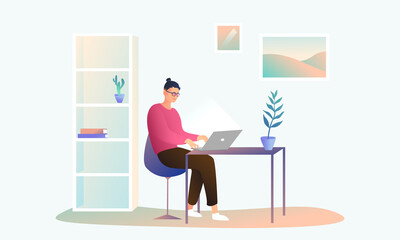A guy with glasses sits in a cozy office at home and works at a computer. A man works remotely in his room, a freshly designed workplace. Interior paintings and light furniture.