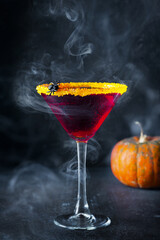 Halloween coctail black widow with red drinks in glass on dark background