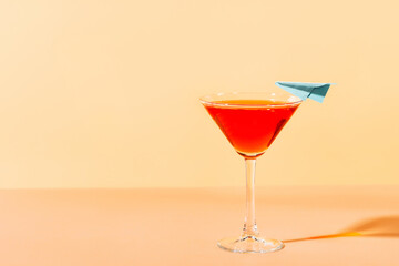 Vacation red cocktail  martini in glass with blue plane  on yellow background