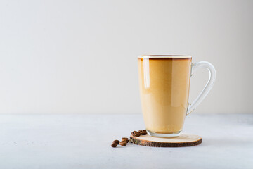 Coffee frappe in tall mug glass with coffee seeds on white background