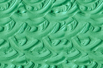 Green cosmetic clay (kelp facial mask, face cream, spirulina body wrap) texture close up, selective focus. Abstract background with brush strokes.