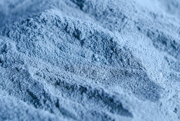 Light blue bentonite facial clay powder (alginate mask, body wrap) texture close up, selective focus. Abstract background with brush strokes.