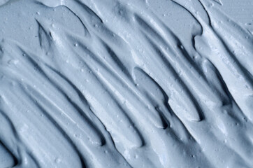 Gray bentonite facial clay (alginate mask, face cream, body wrap) texture close up, selective focus. Abstract background with brush strokes.
