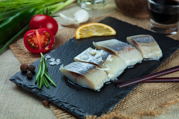 fillet herring serving with vegetables on stone plate