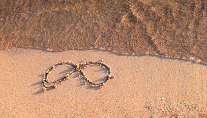 drawing infinity on wet sea sand