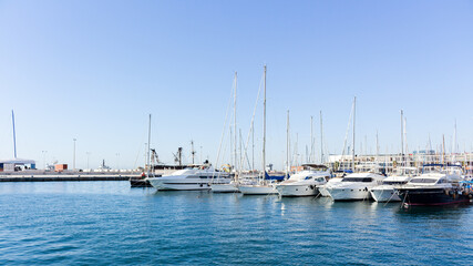 Fototapeta premium Landscape of the port of alicante with the sea with many boats with a clear blue sky in alicante, spain