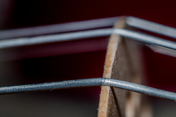 Macro photography of violin's g-string stretched over bridge.