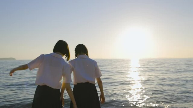 夏の夕暮れの海と女子高生
