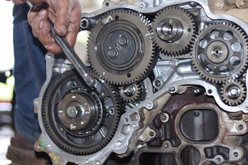 The mechanic is checking the engine.