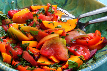 Bowl of fresh peach, tomato and basil salad