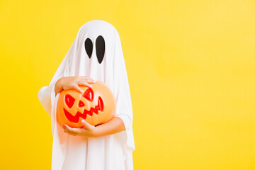 Funny Halloween Kid Concept, little cute child with white dressed costume halloween ghost scary he...