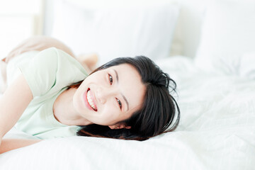 Obraz na płótnie Canvas Asian women laughing in bed