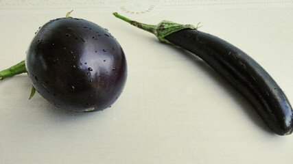 Ripe whole black eggplants on a white background
