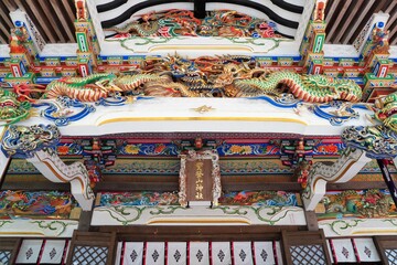 Japanese colorful shrine architecture. Japanese text on center sign is "Hotosan Jinja Shrine (Shrine name)". At Chichibu, Saitama, Japan.
