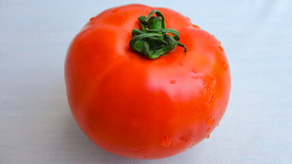 single red organic tomato and red tomatoes on a white background