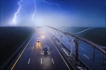 Cars driving on a highway in a pouring rain with a thunderstorm