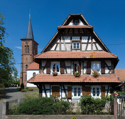 Typisches Fachwerkhaus mit Protestantischer Kirche in Hunspach, Elsass