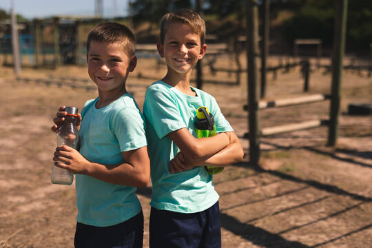 Portrait of two boys holding water bottle at a boot camp