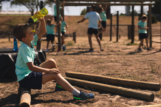 Boy pouring water on his face from a bottle at a boot camp