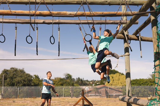 Two boys hanging on ropes on a boot camp