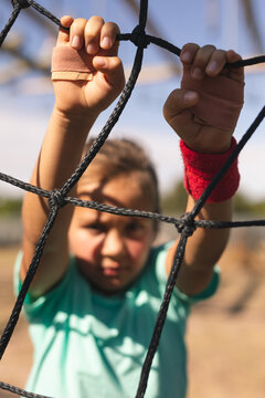 Portrait of boy rope climbing during obstacle course at boot camp