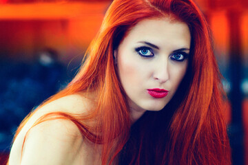 Plakat Portrait of charming young woman with red hair near a motorcycle
