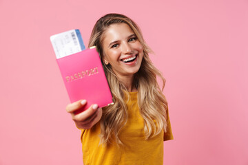 Fototapeta na wymiar Image of happy blonde girl showing passport with tickets