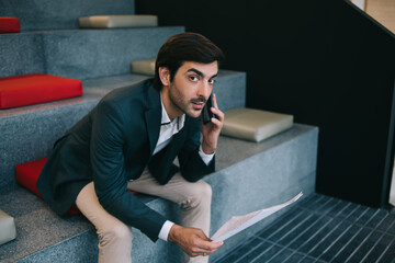 Pensive businessman talking on mobile phone in office