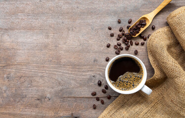 cup of coffee and bean on wooden floor background. top view