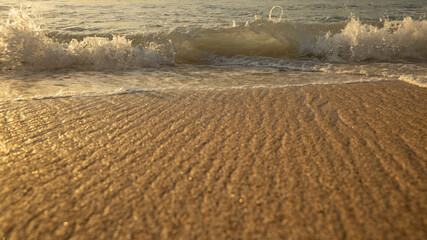 Fototapeta premium Scenic seascape. Milky foam waves at the beach. Sunset time. Waterscape for background. Selected soft art focus. Sunlight reflection on the water and sand. Balangan beach, Bali, Indonesia